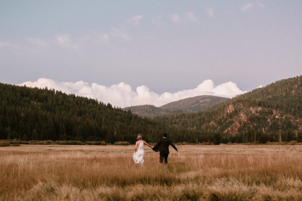 Bride and Groom run through a meadow in Squaw Valley near Lake Tahoe